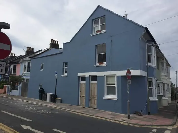 End-of-terrace house after exterior rendering and painting in blue