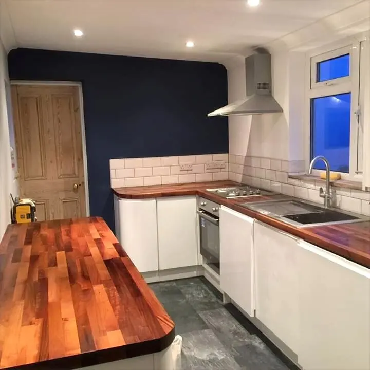 Compact kitchen with white units, metro tiles and a wooden worktop