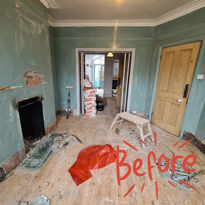 The same living room with damaged plaster and a bare floor before the work