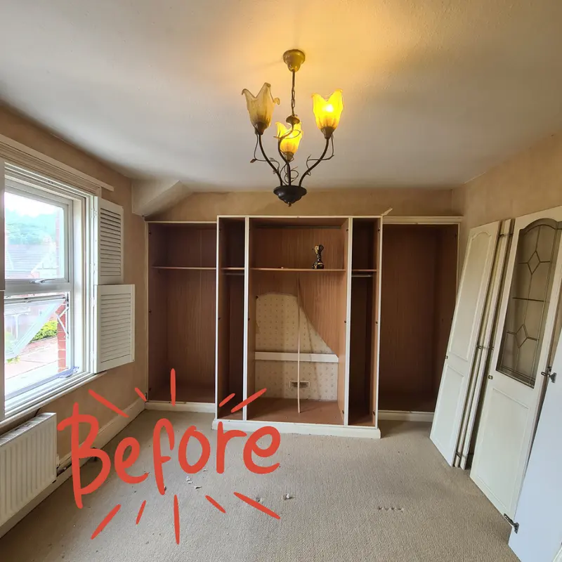 The same room with empty fitted cupboards and a bare carpet before the work